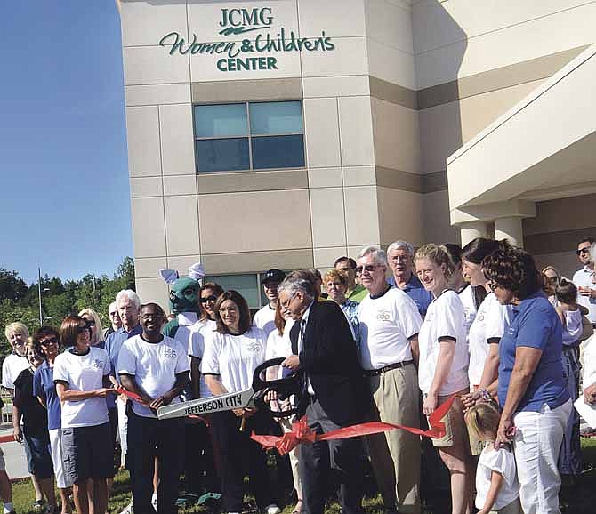 Dr. Richard Jennett, JCMG president, cuts the ribbon at the JCMG Women's and Children's Center Open House on Saturday. The expansion of Jefferson City's health care facilities strengthens the local economy, experts say.