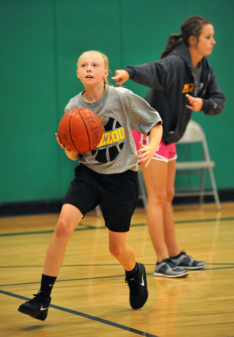 Halie Rackers, a seventh grader at St. Francis Xavier in Taos, goes in for a layup during basketball camp Monday at Blair Oaks Middle School. 