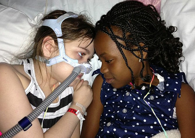 Sarah Murnaghan, left, lies in her hospital bed next to adopted sister Ella on the 100th day of her stay in Children's Hospital of Philadelphia. A federal judge in Philadelphia has made the dying 10-year-old eligible to seek donor lungs from an adult transplant list.
