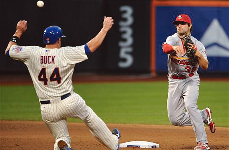 Cardinals shortstop Pete Kozma forces out the Mets' John Buck and turns a double play during Tuesday's game at Citi Field in New York.