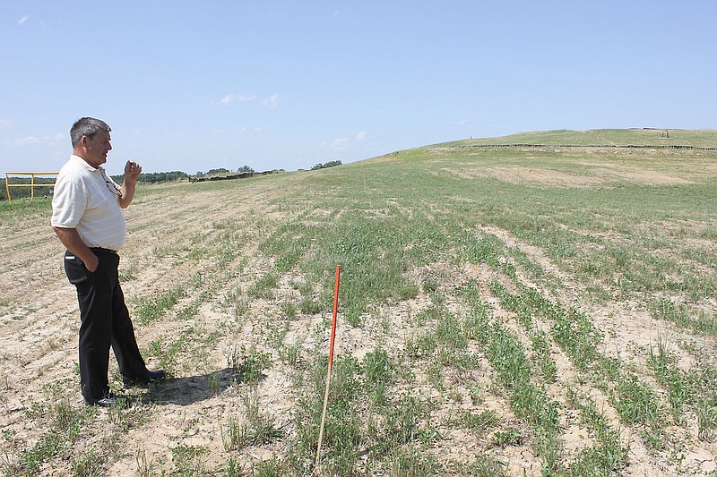 Fulton Solid Waste Manager J.C. Miller inspects the grass at the Fulton Landfill on Wednesday afternoon. Although the landfill stopped accepting trash in May 2011, the site is not considered officially closed by the Missouri Department of Natural Resources until certain standards have been met - including a requirement that 80 percent of the property needs to have vegetative cover.
