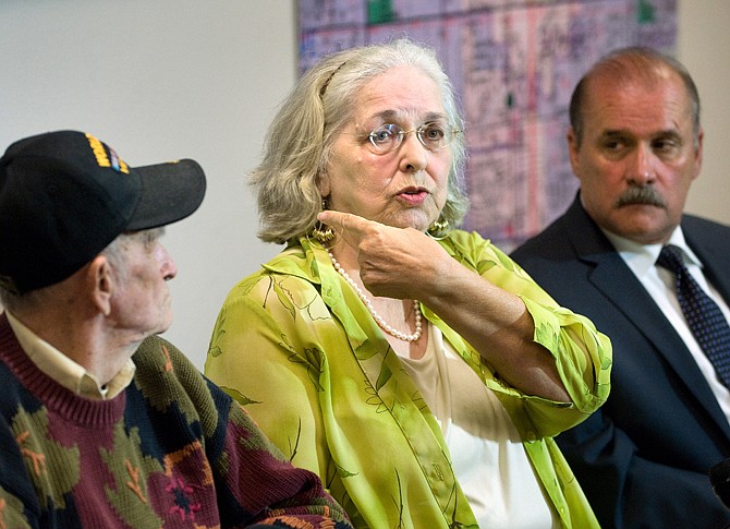 Jan Cooper, 72, talks to the media Tuesday as her husband Bob, 85, left, and OC Sheriff's spokesman Jim Amormino listen during a news conference at the Sheriff's Department station in Stanton. Cooper scared off an intruder at her home in unincorporated Anaheim on Sunday by firing a shot from her .357 Magnum during the attempted break-in. 