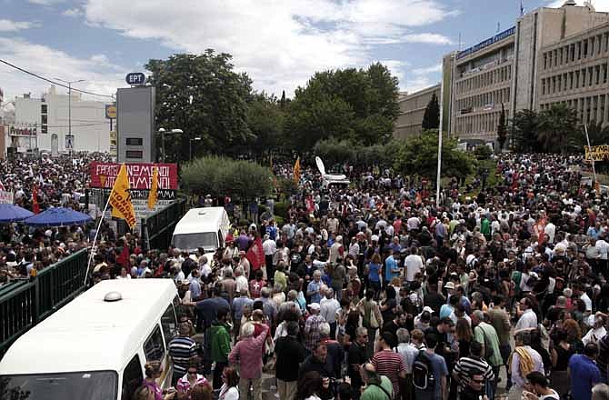 Thousands of protesters take part in a rally outside the Greek state television ERT headquarters during a 24-hour general strike in Athens, on Thursday, June 13, 2013. Greece's fragile governing coalition failed to reach a compromise Wednesday about the closure of the state-run ERT broadcaster. That left the government in a crisis that could lead to early elections, just a year after it was formed to save the country from bankruptcy. 