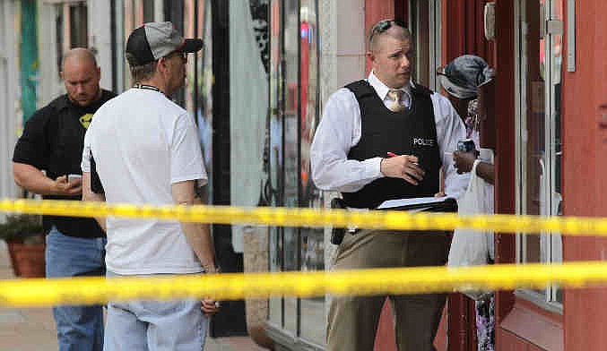 St. Louis police work the scene where four people were found dead in a business along Cherokee Street south of downtown in St. Louis, on Thursday, June 13, 2013. The St. Louis Police Department posted on its official Twitter account that two women and two men are dead. (AP Photo/St. Louis Post-Dispatch, Robert Cohen)