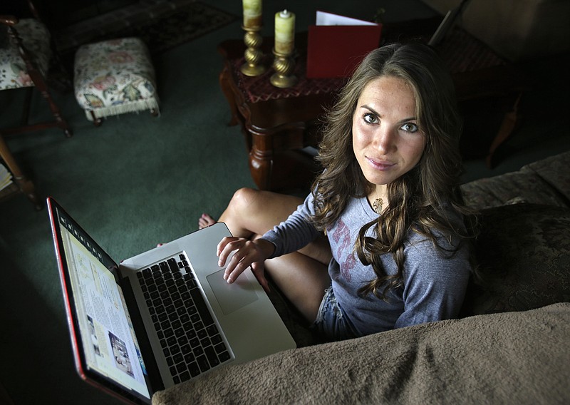 Mandi Grandjean sits inside her home Wednesday in Canton, Ohio. Grandjean, a recent graduate of Miami University in Ohio, says she's fine with the government doing secret surveillance of phone call records and Internet exchanges, but believes it's different when it comes to an employer, or even a coach.