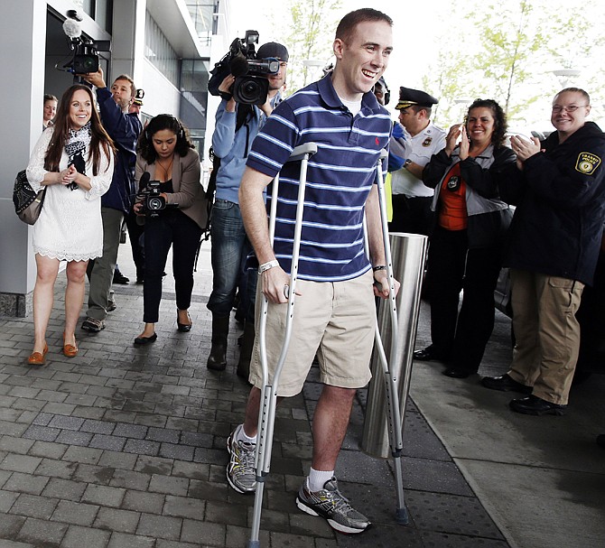 Transit police officer Richard Donohue, center, leaves Spaulding Rehabilitation Hospital in Boston Friday, followed by his wife Kim, left. Donohue was injured during a shoot-out with the Boston Marathon bombing suspects.