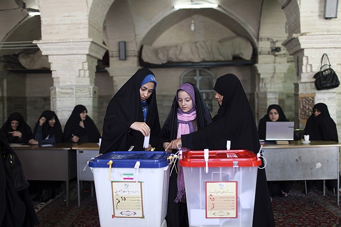 Iranian women vote in the presidential and municipal councils elections, at a polling station in Qom, 78 miles south of the capital Tehran, Iran, Friday.. Iran's supreme leader delivered a salty rebuke to the U.S. Friday as Iranians lined up to vote in a presidential election that has suddenly become a showdown across the Islamic Republic's political divide: hard-liners looking to cement their control and re-energized reformists backing the lone moderate.