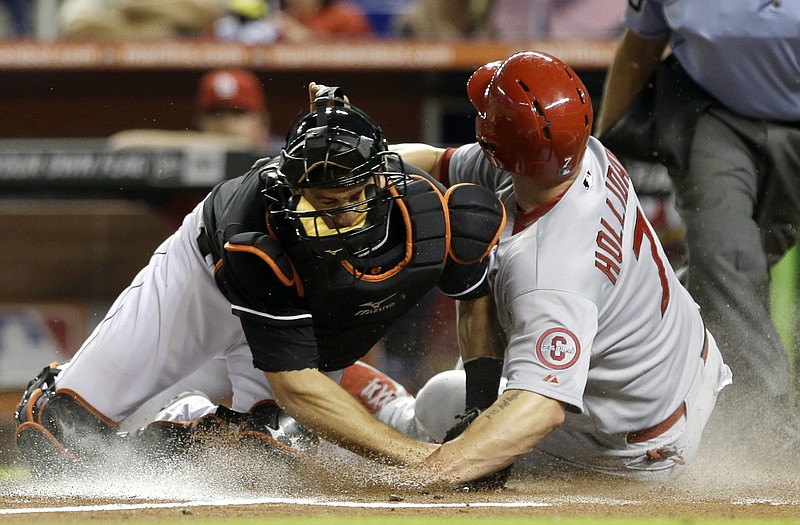 The Cardinals' Matt Holliday slides safely into home plate as Marlins catcher Jeff Mathis is late on the tag in the first inning Friday in Miami. Holliday scored on a base hit by Yadier Molina.