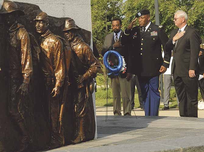 Juneteenth-Jefferson City President W.T. Edmonson, left, Missouri National Guard Lt. Col. Eddie Brown, center, and Third Ward Councilman Bob Scrivner salute as Taps is played in the distance following the ceremonial laying of the wreath at the base of the Lincoln University Soldiers' Memorial during the Juneteenth Heritage Celebration's Emancipation program on Friday afternoon.