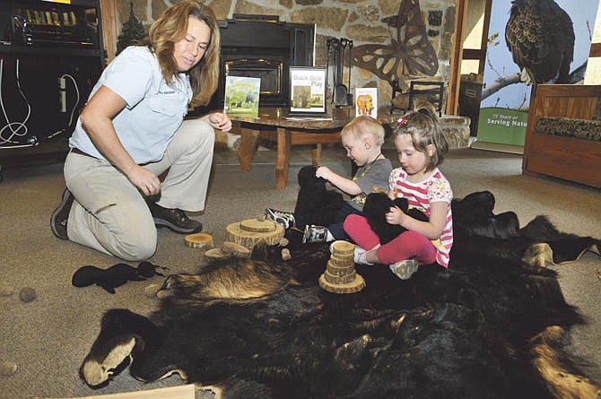 In this file photo from March 2012, Trana Madsen, a Naturalist at Runge Nature Center, shows John and Ruth Cassmeyer, some of the items black bears use to survive.