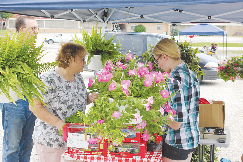 Danny and Renee Farris buy basil and other plants from Elizabeth Essen. The Farrises had searched through local greenhouses in Jefferson City and Columbia for fresh basil to no avail, but were able to pick some up on their first trip to the New Bloomfield Farmers Market this year.