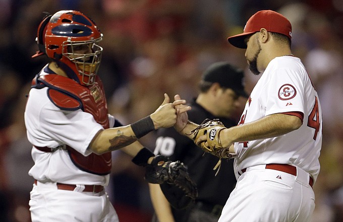 Cardinals catcher Yadier Molina and relief pitcher Edward Mujica celebrate following St. Louis' 5-2 victory Monday night against the Chicago Cubs at Busch Stadium.