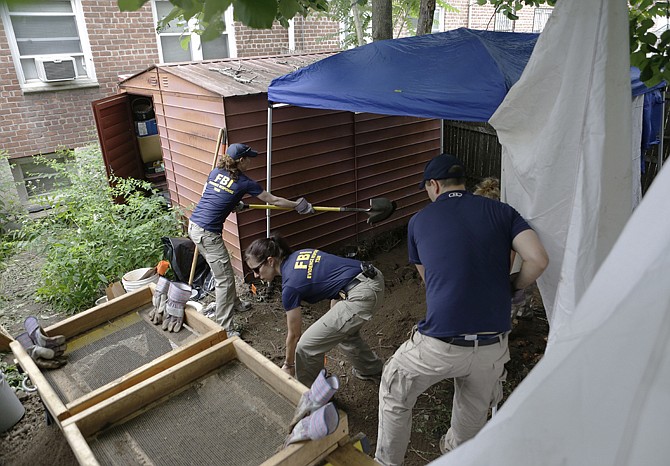 FBI agents replace dirt after searching in the backyard of a New York city house once occupied by a famous gangster in New York. The work started Monday at the home of James Burke, a Lucchese crime family associate known as "Jimmy the Gent." The Queens house is still owned by the Burke family, but others now live there.