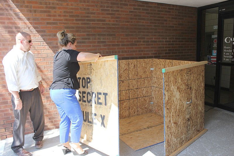 Glenn Harris, commercial lender, and Nicole Elliott, marketing assistant of The Callaway Bank, build a special storage crate for the bank's mule in preparation for Friday's Callaway Cup Derby at the Fulton Street Fair. The Callaway Bank also participates in a separate SERVE Challenge with Ovid Bell Press and Moser's.