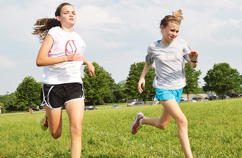 Lily Tharp (left) and Katie Ruth, both 13, approach the end of Friday's 5K run to conclude their week at Jefferson City High School's cross country camp. Numerous local runners attended this week's camp at Cole County Park.