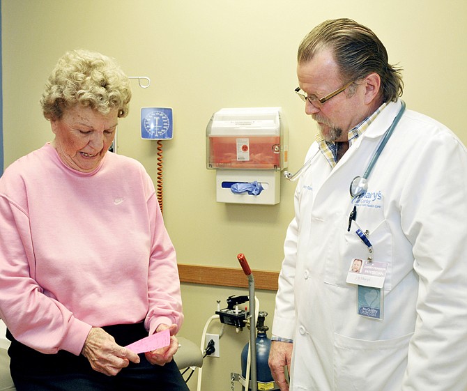 Dr. Garry Pearson of St. Mary's Jefferson City Medical Clinic, listens as patient Iola Potts of Tipton goes through her list of questions in April. Potts was a patient at the Tipton clinic, but drives to Jefferson City to see her favorite doctor. 