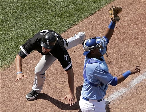 Jordan Danks of the White Sox dives past Royals catcher Salvador Perez to score in the top of the ninth inning Saturday afternoon at Kauffman Stadium.