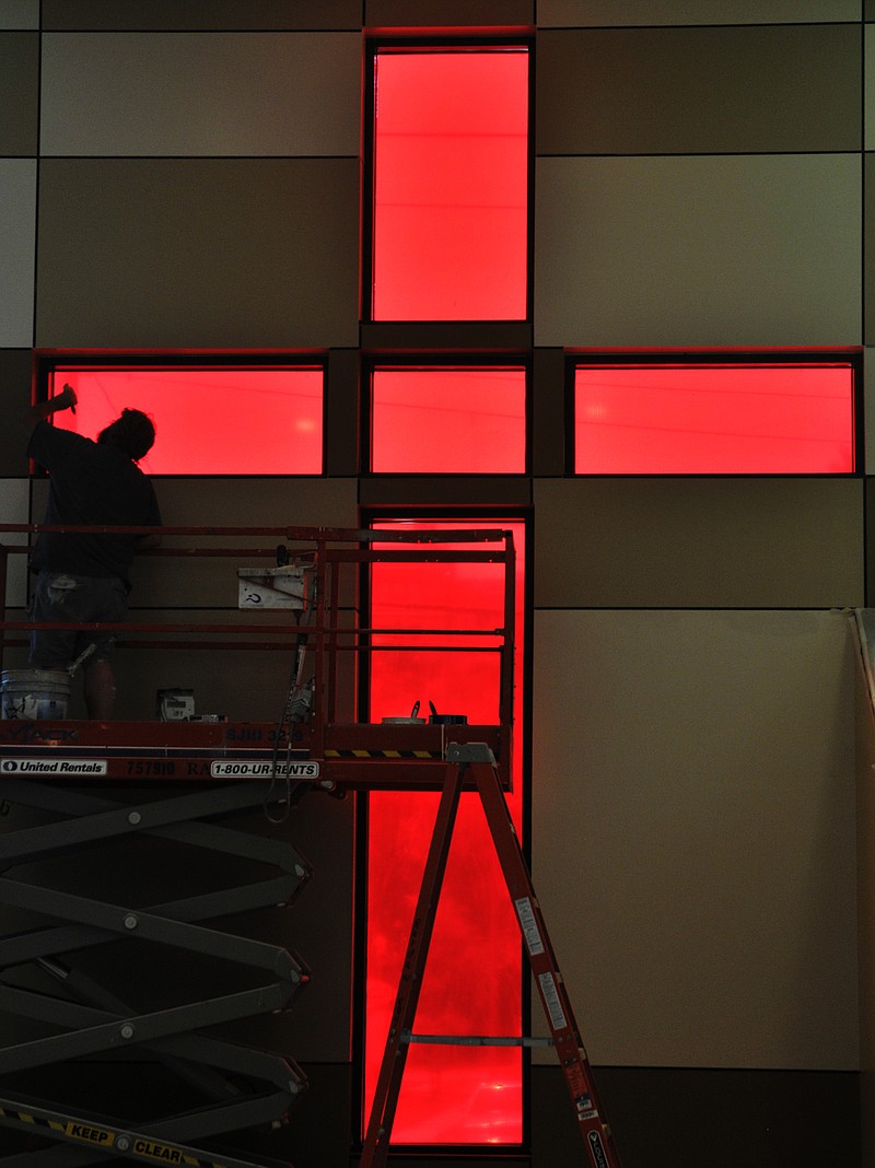 Greg Renfrow, of Extreme Painting and Wallpapering, applies finishing touches to the sanctuary's window frame. Construction of the new Quinn A.M.E. Chapel on Lafayette Street is nearing completion.