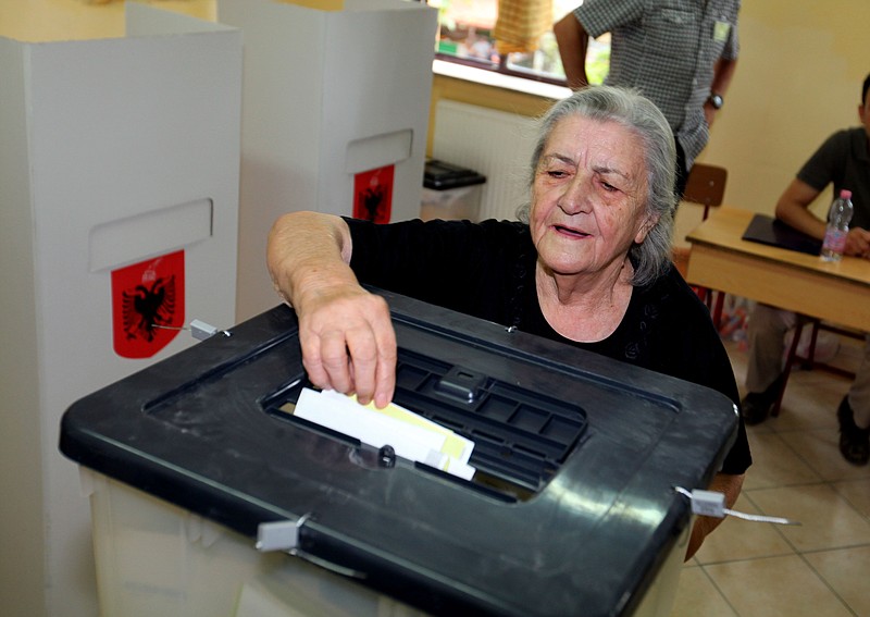 An Albanian casts her vote Sunday in Tirana in elections seen as an important test of their country's ambitions, but an ongoing dispute over who counts the ballots could leave the result up in the air.