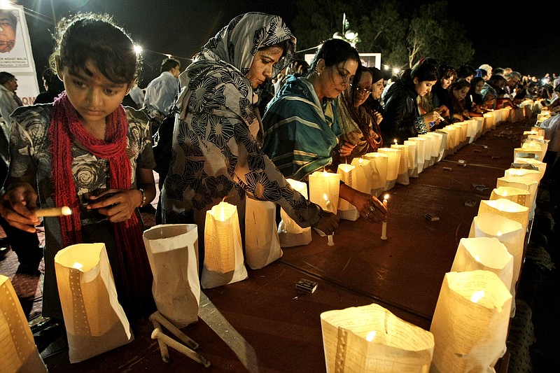 Pakistani workers of political party Muttahida Qaumi Movement light candles Sunday during a protest to condemn the killing of foreign tourists by militants in Karachi, Pakistan.