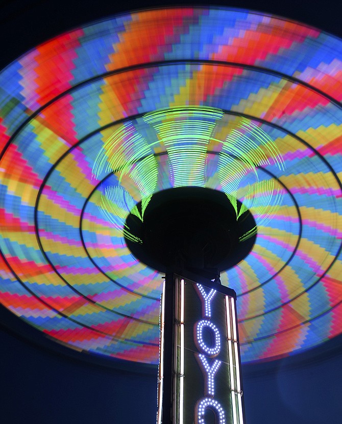The Yo-Yo swing ride spins in a kaleidoscope of colors during the Happyland carnival at the Capital Mall on Friday evening.