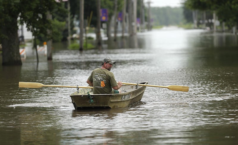 Jim Johnson rows his boat down Main Street on Tuesday in New Hartford, Iowa. Hundreds of residents obeyed an order to evacuate their homes in this northeast Iowa town Tuesday before floodwaters from a rising creek could strand them.