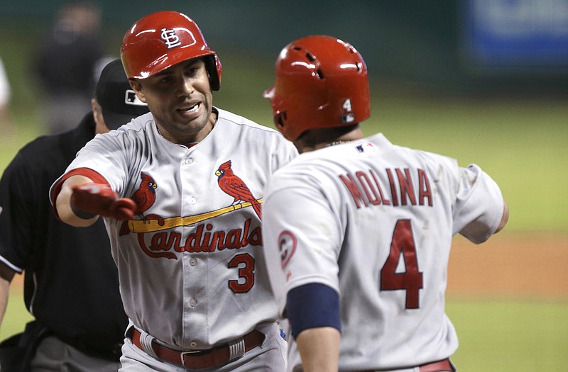 Carlos Beltran is welcomed home by Cardinals teammate Yadier Molina after hitting a two-run home run during the sixth inning of Tuesday night's game against the Astros in Houston.