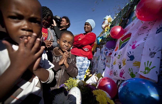 Children from a creche pray for the health of Nelson Mandela outside the entrance to the Mediclinic Heart Hospital, where former South African President Nelson Mandela is being treated in Pretoria, South Africa.