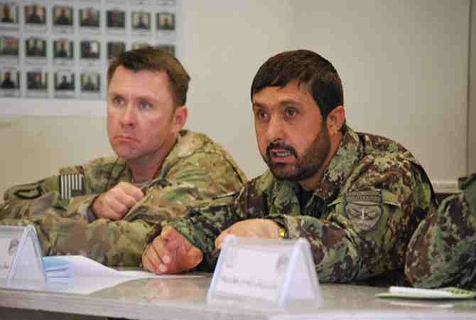 In a Wednesday, May 15, 2013, photo U.S. Army Lt. Col. Matthew Stader, left, listens to a briefing in Jalalabad, Afghanistan, alongside his Afghan counterpart, Brig. Gen. Dadan Luwang, commander of the 4th Brigade, 201st Corps of the Afghan National Army. Stader, of Annapolis, Md. and assigned to the 101st Airborne Division, is serving as an adviser to the Afghan brigade during the transition to leave Afghan forces in charge of security ahead of the 2014 drawdown of U.S. forces.