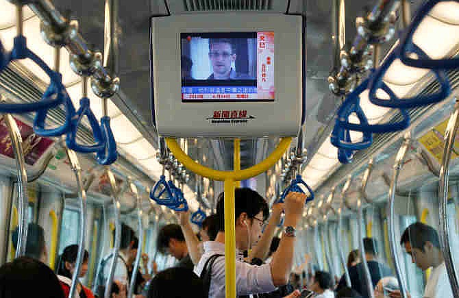 In this June 16, 2013 file photo a television screen shjows the news of Edward Snowden, a former CIA employee who leaked top-secret documents about sweeping U.S. surveillance programs, in the underground train in Hong Kong. Whisked out of a luxury Hong Kong hotel, vanishing into a mysterious wing of the Moscow airport, Edward Snowden's continent-jumping, hide-and-seek game seems like the stuff of a pulp thriller _ a desperate man's drama played out before a worldwide audience trying to decide if he's a hero or a villain. 