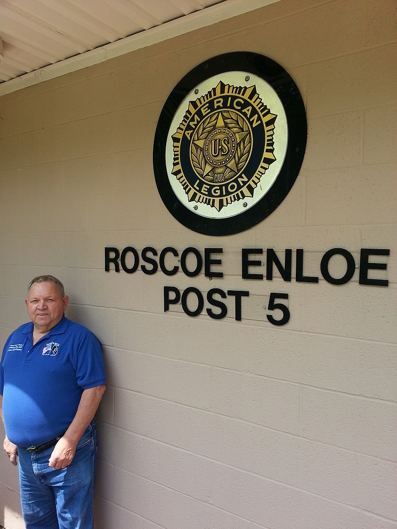 Morgan Walker, adjutant for the American Legion Post 5 in Jefferson City, stands next to a sign denoting the post's namesake, Roscoe Enloe. Enloe fought with a Missouri National Guard unit federalized during World War I. He was the first Cole County resident killed during the war.