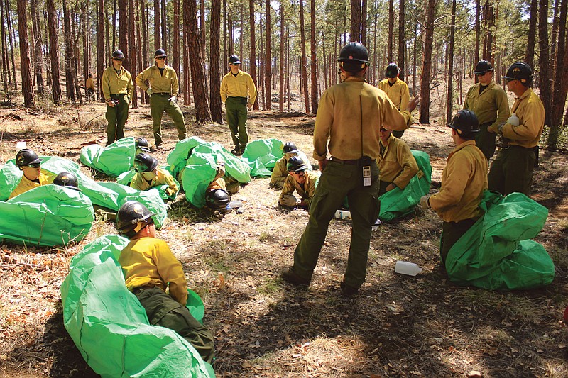 Phillip Maldonado, a squad leader with the Granite Mountain Hotshots, trains crew members on setting up emergency fire shelters in 2012. On Sunday, 19 members of the Prescott, Ariz.-based crew were killed in the deadliest wildfire involving firefighters in the U.S. for at least 30 years.