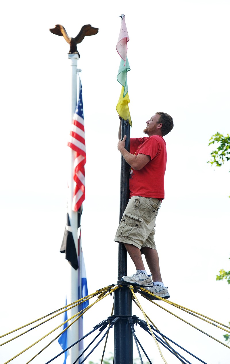 Brett Reinke, one of the Southern Fun Carnival co-owners, climbed to the top of the merry-go-round to put up the flag Tuesday while setting up for this week's carnival rides and games. They are stationed on Capitol Avenue, Madison and Monroe Streets, and the News Tribune lower parking lot. Starting at 4 p.m. Wednesday and through Thursday night, the rides, games and food trailers will be open to the public as they celebrate July 4th in downtown Jefferson City.