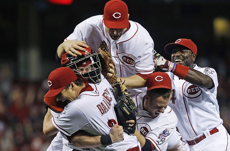 Reds starting pitcher Homer Bailey (front) is mobbed by catcher Ryan Hanigan (left), third baseman Todd Frazier (top), shortstop Zack Cozart and second baseman Brandon Phillips (right) after Bailey threw a no-hitter against the Giants on Tuesday in Cincinnati.