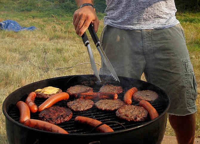  In this Wednesday, July 4, 2012 file photo, Chris Andreski grills hamburgers and hot dogs in Arlington, Va.