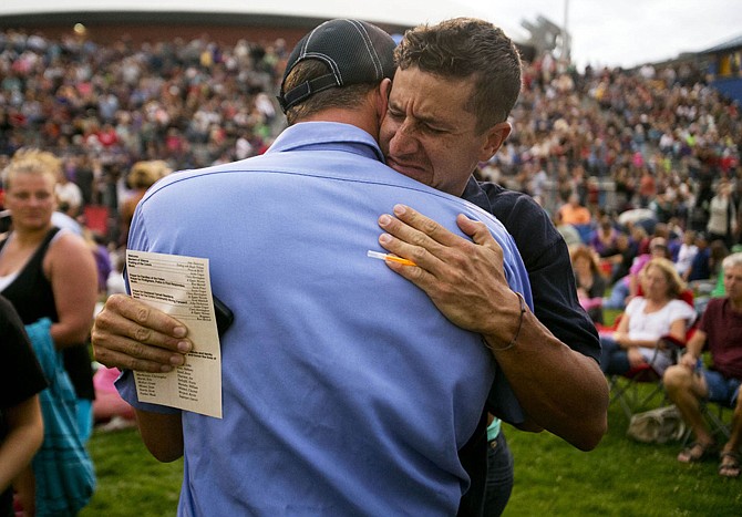 Cooper Carr, right, a Sedona Firefighter and formerly of the Prescott Hot Shots, hugs Prescott Fire Captain Kevin Keith during a vigil for the 19 firefighters killed battling the Yarnell Hill Fire.
