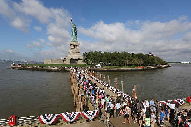 Visitors to the Statue of Liberty disembark onto Liberty Island from the first ferry to leave Manhattan, Thursday, July 4, 2013, in New York. The Statue of Liberty finally reopened on the Fourth of July months after Superstorm Sandy swamped its little island in New York Harbor as Americans across the country marked the holiday with fireworks and barbecues. 
