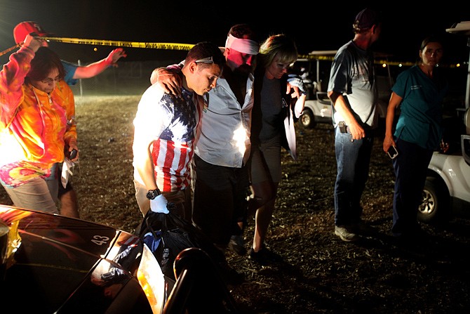 Witnesses and the injured comfort one another after a fireworks incident in Simi Valley, Calif. Police are still investigating what caused Thursday night's explosion, but it appeared a firework detonated prematurely in its mortar, knocking over a row of others, police said.