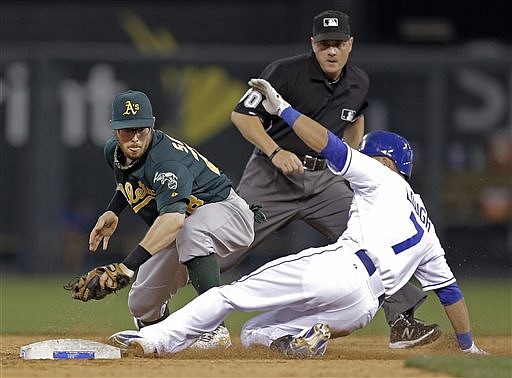 David Lough of the Royals beats the tag by Athletics second baseman Eric Sogard for a double during the ninth inning of Friday night's game at Kauffman Stadium.