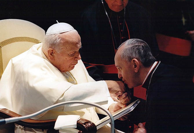 Jorge Mario Bergoglio, Archbishop of Buenos Aires, right, kisses the hand of Pope John Paul II during a ceremony at the Vatican. Bergoglio, who became Pope Francis on March 13, cleared Pope John Paul II for sainthood, approving a miracle attributed to his intercession and setting up a remarkable dual canonization along with another beloved pope, John XXIII.