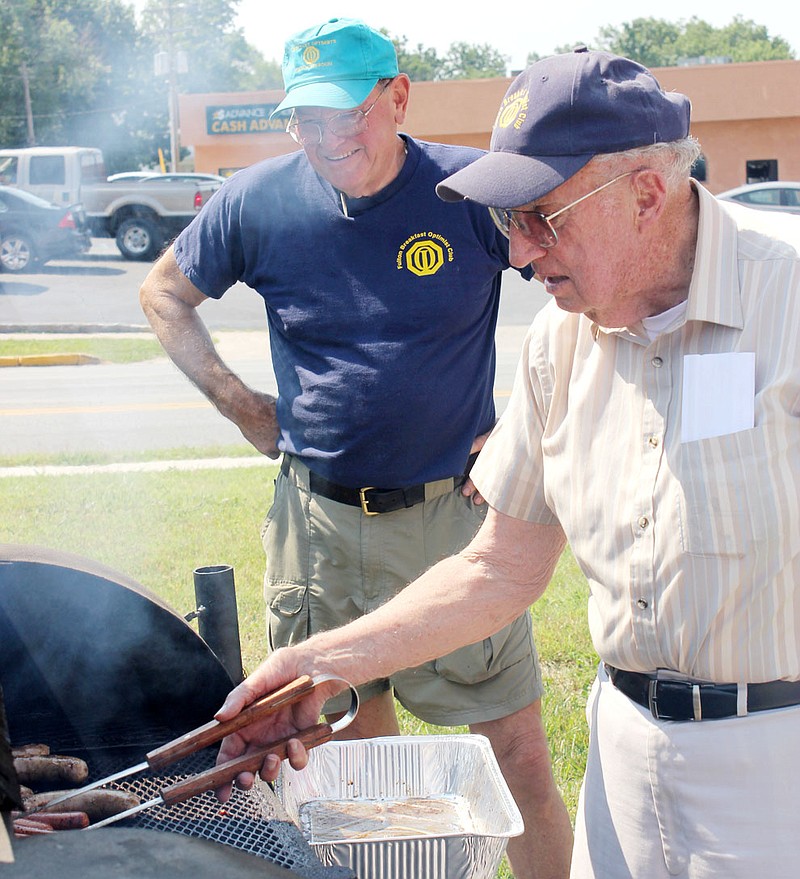 Ron Baldwin of the Fulton Breakfast Optimist Club turns meat during the club's fundraiser Saturday on the Auto Zone parking lot in Fulton. With him is Joe D. Holt, Fulton attorney, former Callaway County circuit judge and state representative. They grilled pork steaks, bratwurst and hotdogs during the fundraiser. Optimist Gary Taylor said the club will have another barbecue fundraiser next month.