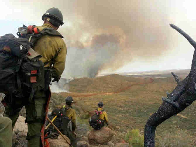  In this photo shot by firefighter Andrew Ashcraft, members of the Granite Mountain Hotshots watch a growing wildfire that later swept over and killed the crew of 19 firefighters near Yarnell, Ariz., Sunday, June 30, 2013. Ashcraft texted the photo to his wife, Juliann, but died later that day battling the out-of-control blaze. The 29-year-old father of four added the message, "This is my lunch spot...too bad lunch was an MRE."