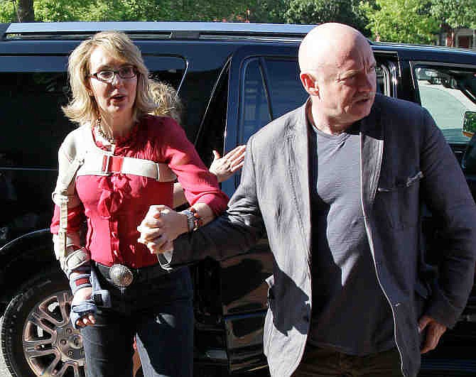 In this photo taken Friday, July 5, 2013, former Arizona Rep. Gabrielle Giffords and her husband, retired astronaut and combat veteran Capt. Mark Kelly, arrive to meet with local supporters and parents of Sandy Hook Elementary School victims at the Orchard Street Chop Shop in Dover, N.H. Three years after being shot in the head, Giffords is in New Hampshire to urge support for background checks on gun purchases. 