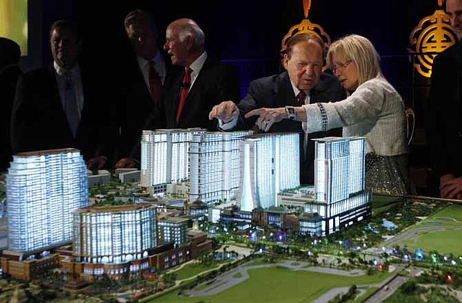 Las Vegas Sands Chairman and CEO Sheldon Adelson, second right, and his wife, Miriam Ochsorn, right, look at a model of the Sands Cotai Central resort during a news conference in Macau on Wednesday, April 12, 2012 to announce the launch of the $4.4-billion complex in Macau, a special administrative region of China. 