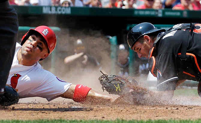 St. Louis Cardinals' Carlos Beltran, left, is safe at home for a stolen base ahead of the tag from Miami Marlins catcher Jeff Mathis during the third inning of a baseball game Sunday, July 7, 2013, in St. Louis.