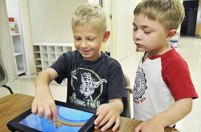 Kyle McCarty, right, looks on as Nolan Bennett traces letters and repeats words that start with those particular letters. Both will be in kindergarten at Blair Oaks this fall. 
