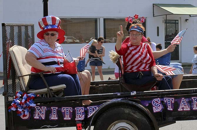 Two patriotic ladies eye the crowd from their float in Eldon's Fourth of July parade on Saturday, July 6, 2013.