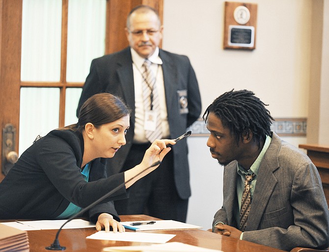 Cole County Court Marshal Donny Schulte watches as attorney Michelle Hinkl confers with client and murder defendant Khiry Summers, while waiting Monday for a jury to be selected for his trial. Summers, who was convicted by the jury on Tuesday, was the third person accused of the murder of Keith Mosely, 34,Columbia.