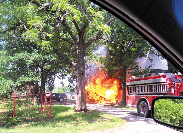 A shed and part of a residence on Highway O just outside of California are engulfed in flames after fireworks started a fire in the shed at approximately 10:30 a.m. Thursday, July 4, 2013, according to California Rural Fire Chief Steve Walters. 