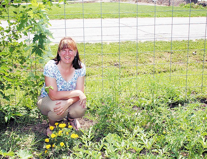 Karen Korenberg, California, amidst the marigolds and cherry tomato plants in her garden. Korenberg said she plants the marigolds around her garden as a border, because the smell deters bugs.